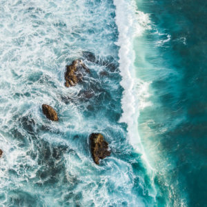 Aerial view of crashing waves on rocks. View from above, drone photo, beautiful nature background